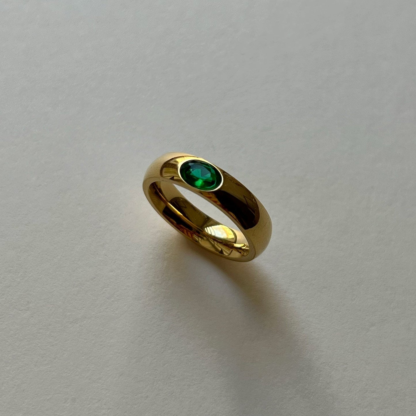 Gold ring with shimmering gemstone in green